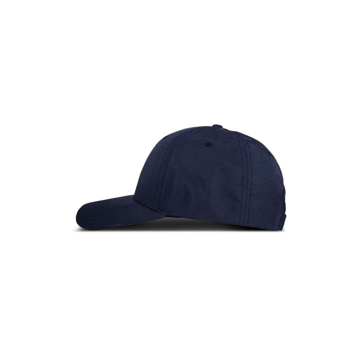 A side view of the Reebok 1895 Pro, a plain navy blue baseball cap, is displayed against a white background.