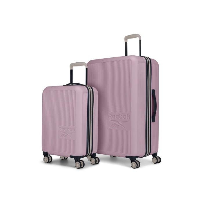 The Reebok Action Duo 2 Piece Luggage Set features two pink hard-shell suitcases with textured surfaces, white handles, dual spinner wheels, and the Reebok logo, all displayed against a white background.