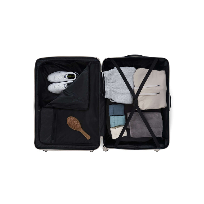 Open the Reebok Action Duo 2 Piece Luggage Set to reveal neatly packed essentials: two pairs of pants, a shirt, hoodie, shoes in a separate compartment, and hairbrush in mesh pocket. Straps keep contents secure—perfect for organized travel.