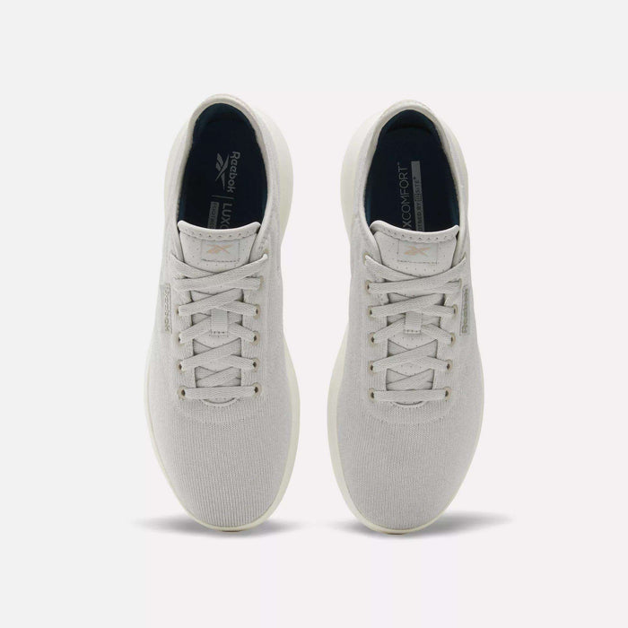 The Reebok Active Lite Shoes, in light gray with white soles, are shown from above on a plain white background. These comfortable lace-up shoes feature a sleek, minimalist design.