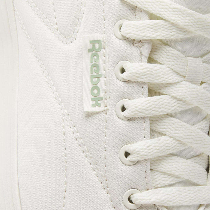 Close-up of Reebok Active Lite Shoes highlighting the iconic logo tag, detailed stitching, and crisp white laces—these minimalist sneakers combine classic design with modern Reebok style.