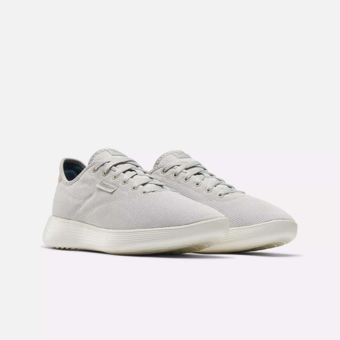Reebok Active Lite Shoes in light gray feature a minimalist design, lace-up closure, and white soles. Displayed on a plain white background, these comfortable shoes are perfect for everyday wear.