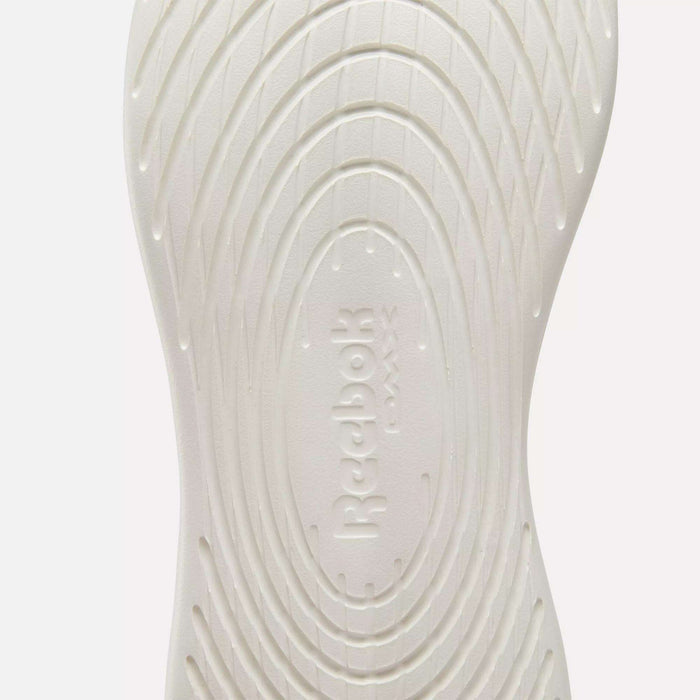 Close-up of the white sole on Reebok Active Lite Shoes, showcasing concentric oval grooves and embossed "Reebok" branding at the center.