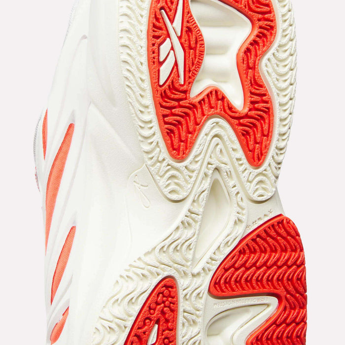 Close-up of the sole on the Reebok Angel Reese 1 Shoes for Big Kids, featuring bold wavy red and cream details, textured tread for superior grip, and a partial logo—ideal kids basketball shoes combining standout style and performance.
