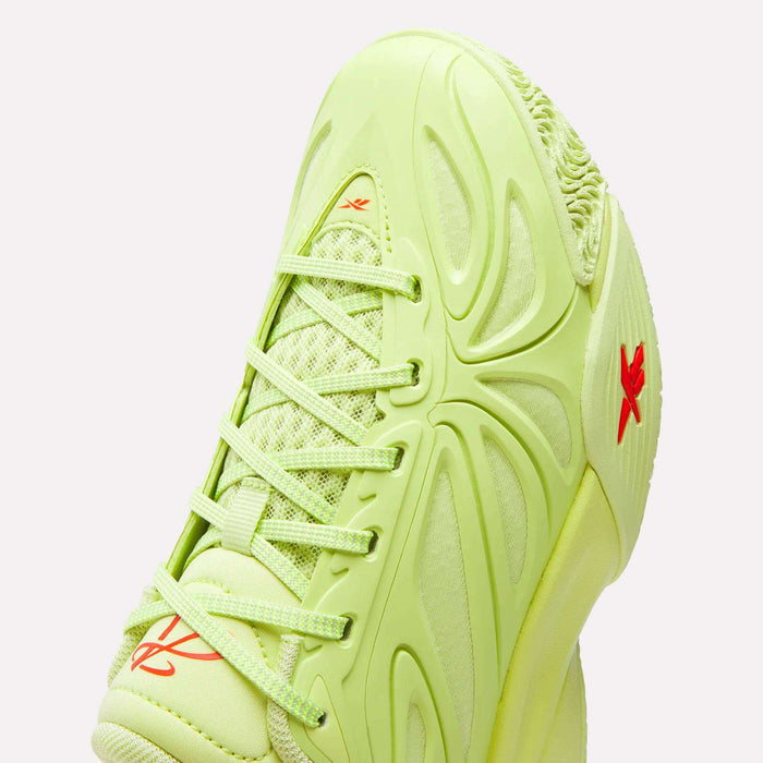 A close-up of the Angel Reese 1 Shoes for big kids by Reebok highlights their neon green color, wavy molded patterns, mesh panels, and orange Reebok logos—plus matching green laces and sole for standout style on and off the court.