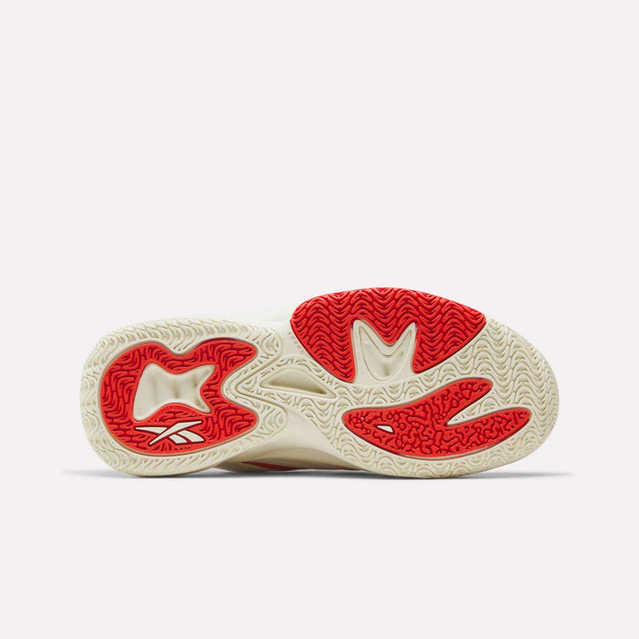 The image shows the sole of the Reebok Angel Reese 1 Shoes - Big Kids, mainly off-white with red rubber sections and wavy textured tread, offering both grip and style—ideal for young basketball players seeking performance.