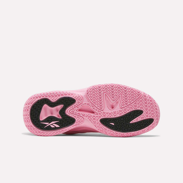 The image displays the pink sole of the Reebok Angel Reese 1 Shoes - Big Kids, featuring wavy tread patterns and black sections with a small Reebok logo, reflecting the bold style characteristic of kids’ basketball footwear.