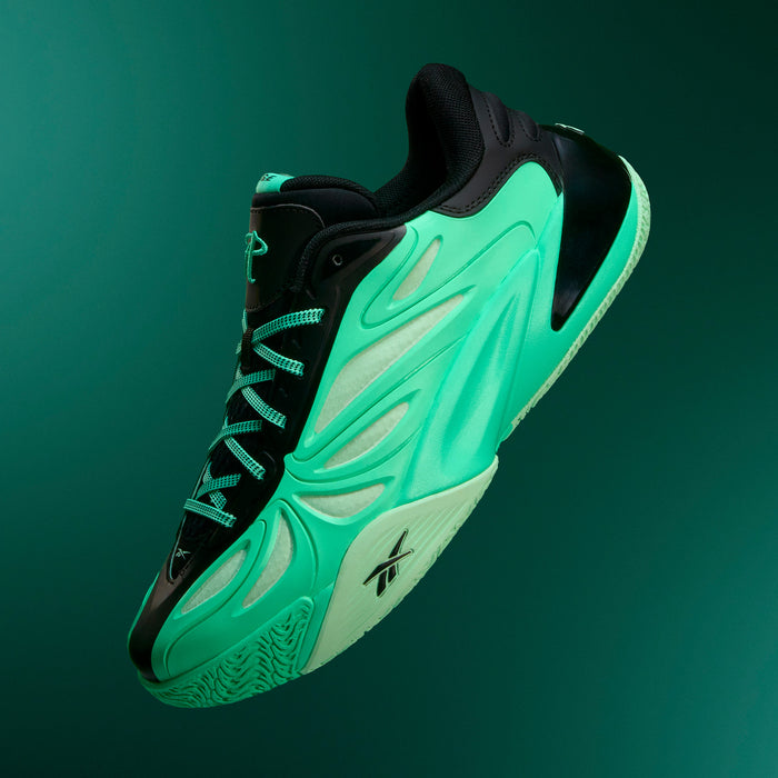 The Reebok Angel Reese 1 Basketball Shoes in green and black feature a dynamic, wavy design and black laces, floating against a dark green gradient background. These sneakers showcase a unique textured sole inspired by the Reebok Energy Return System, delivering enhanced comfort reminiscent of elite performance basketball footwear.