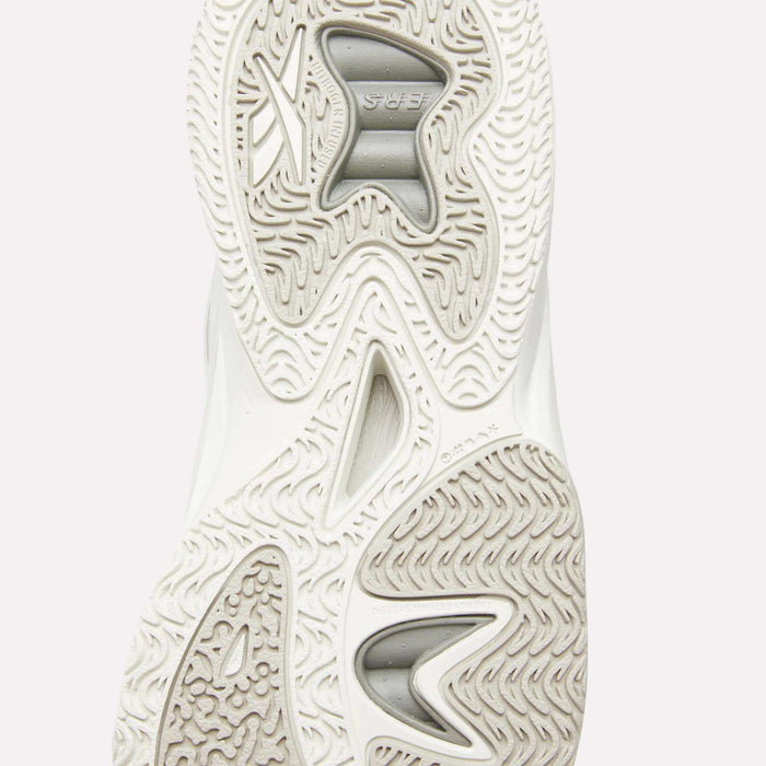 Close-up of the textured white outsole on the Reebok Angel Reese 1 Basketball Shoes, showcasing wavy and herringbone patterns with deep grooves for traction. Two visible grey rubber inserts provide extra grip and stability.