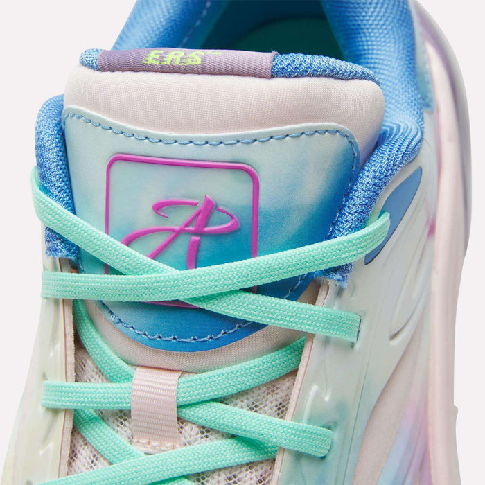 Close-up of the Reebok Angel Reese 1 Basketball Shoes, featuring turquoise laces, a pastel blue and pink tongue, mesh accents, and a stylized A logo on a purple-blue patch—all in a soft gradient pastel color scheme.