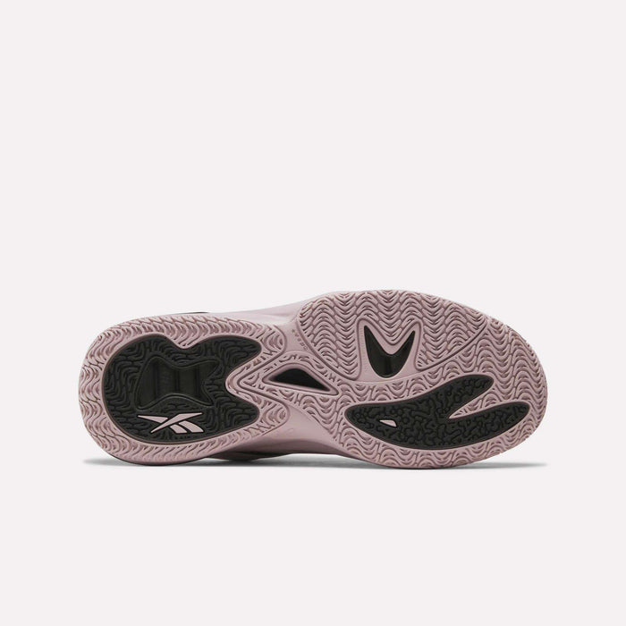 The image shows the sole of Reebok Angel Reese 1 Basketball Shoes, mainly light mauve with black rubber areas and wavy grip patterns. The Energy Return System and a visible Reebok logo near the heel highlight its basketball performance focus.