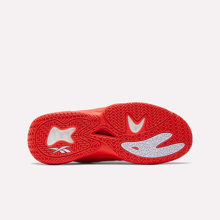 The image shows the red sole of the Reebok Angel Reese 1 Basketball Shoes with intricate wavy tread, white accents, and a white Reebok logo. The design features performance basketball elements and the Reebok Energy Return System.