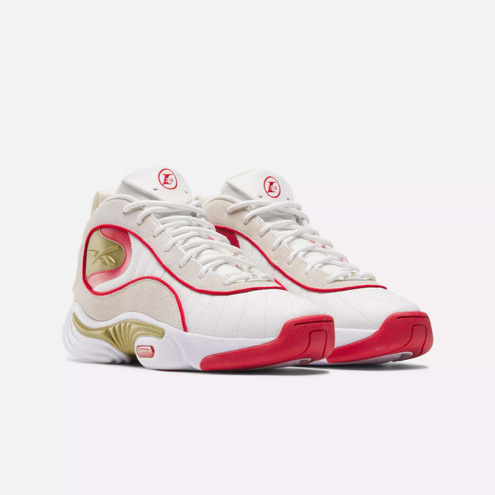 The Reebok Answer III Basketball Shoes are stylish mid-top sneakers featuring white uppers, beige suede accents, red trim, gold details, the iconic Reebok logo, and a unique wavy sole inspired by retro basketball shoes.