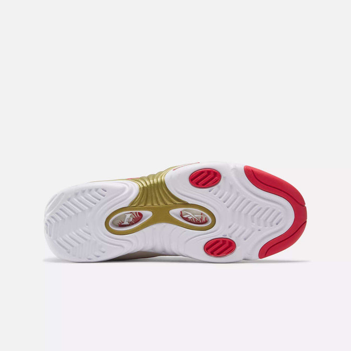The image shows the bottom view of Reebok's Answer III Basketball Shoes, featuring a wavy white sole, gold center section, red circular details, and red accents on the toe and heel—a classic retro basketball sneaker.