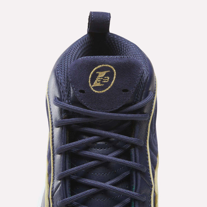 Top view of navy blue Reebok Answer III Shoes with yellow accents, laces, and a circular LB logo on the tongue. Inspired by retro basketball designs with a mesh interior and heel pull tab, echoing Allen Iverson’s iconic style.