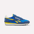 The Reebok Aztec II Shoes feature blue and yellow suede and mesh panels, vintage running shoe style, the Reebok logo with Union Jack on the side, a white heel tab, and a black rubber sole.