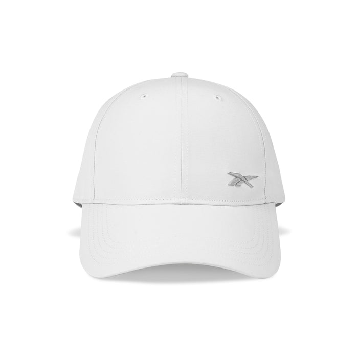 The Reebok Badge Cap is a plain white adjustable sports cap with visible stitching, a curved brim, and a small light gray embroidered logo on the front left side, shown from the front against a white background.