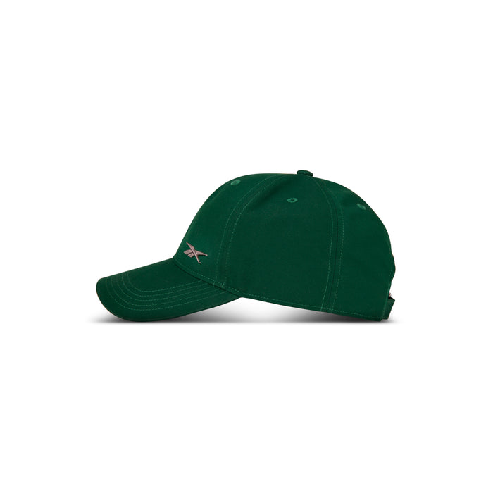 A dark green Reebok Badge Cap with white stitching and a small side logo, featuring a moisture-wicking Speedwick sweatband, shown in profile against a plain white background.