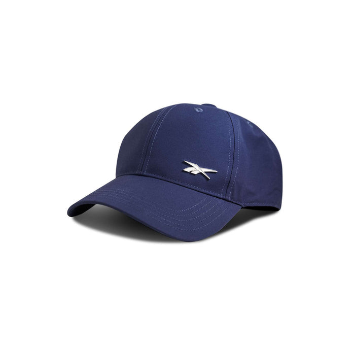 The Badge Cap by Reebok is a navy blue baseball cap featuring a curved brim and a small white Reebok logo on the front, displayed against a white background.