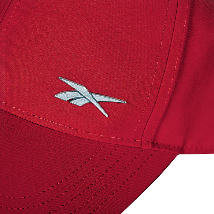 Close-up of the Reebok Badge Cap in red, showcasing a silver logo on the front panel, detailed seams, and an adjustable buckle for a customized fit.