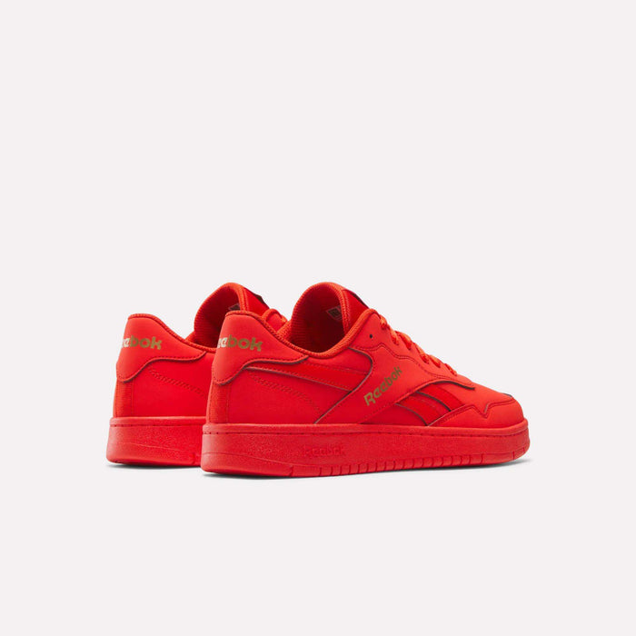A pair of BB 1000 Retro Basketball Shoes by Reebok, shown from the side and back angles in bright red with gold Reebok branding on the side and heel, are set against a plain white background for an authentic throwback court style.