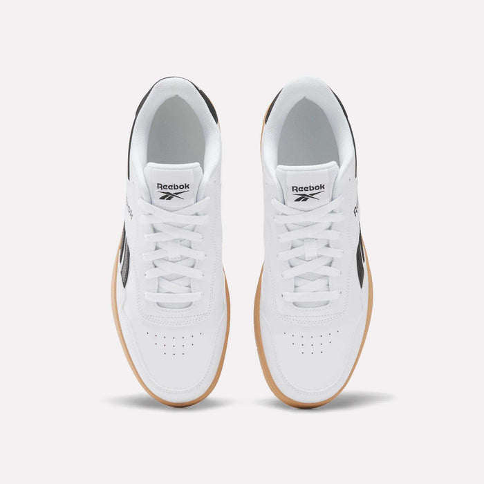 A pair of BB 1000 Shoes by Reebok with a white leather upper and gum soles, seen from above. These sneakers feature black accents, white laces, and the Reebok logo on the tongues and sides, highlighting classic ’80s heritage style.