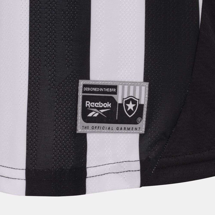 Close-up of the Botafogo Women's Home Jersey by Reebok for the 25/26 season, showing black and white stripes, club crest, and detailed stitching with visible fabric texture.