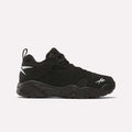 The Reebok Brutus Low Shoes feature a black mesh and synthetic upper, chunky sole, and white Reebok logos on the side and toe—delivering bold street style in a sleek side profile view against a white background.