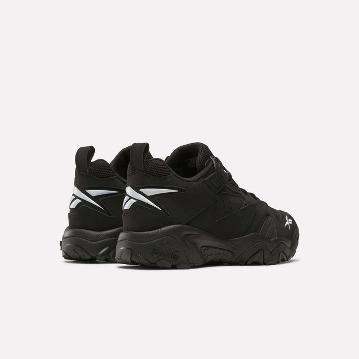 A pair of Brutus Low Shoes by Reebok in black, featuring chunky soles, white side logos, and reflective details; shown from the back and side on a plain light background—ideal for street-ready style.