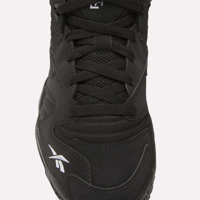 Close-up of the Brutus Low Shoes by Reebok in black, featuring black laces, mesh and leather upper, and a white logo on the toe—perfect for adding street-ready style to your look.