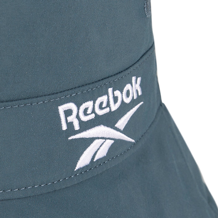 Close-up of a blue Reebok Bucket Hat with the brand's logo and name embroidered in white on recycled nylon fabric.