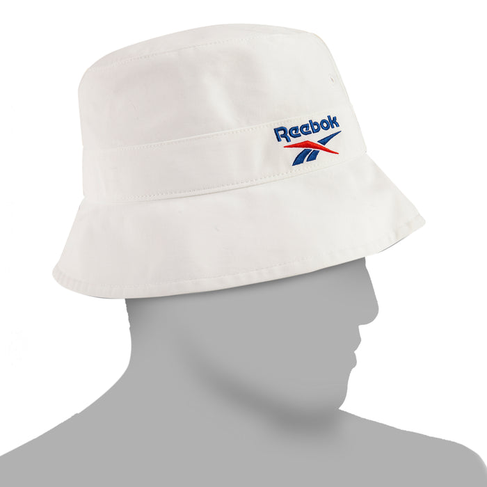 The Reebok Bucket Hat, made from recycled nylon with the signature blue and red logo, adds streetwear style on a mannequin's head against a minimalist backdrop.