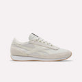 A side view of Reebok Camargue Shoes in white and beige showcases a low-profile, lace-up design with a slightly raised sole, subtle stitching, and minimalist detailing for timeless style.