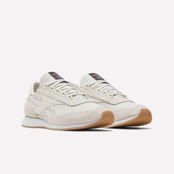 A pair of Reebok Camargue Shoes in off-white with gum rubber soles, white laces, and a black Reebok logo tag on the tongue, displayed against a plain white background.