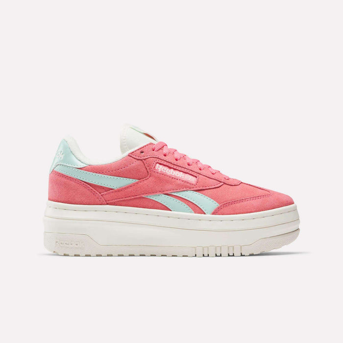 The Reebok Campio Extra Women's Shoes are shown in pink with light blue side stripes, white laces, and a thick platform midsole, displayed in side profile against a plain white background.