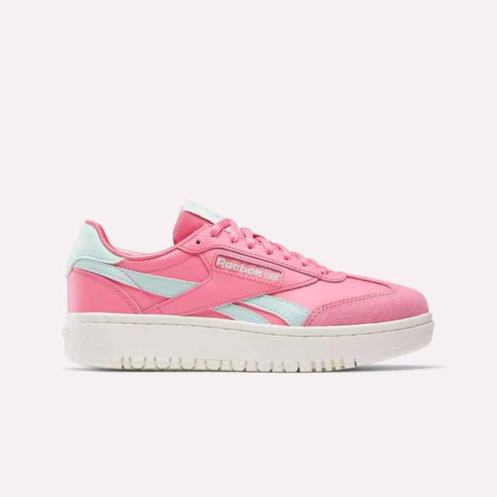 The Reebok Campio XT Double Shoes for big kids feature a pink design with light blue accents and a white sole, shown in a side view—ideal retro sneakers for girls seeking stylish Reebok footwear.