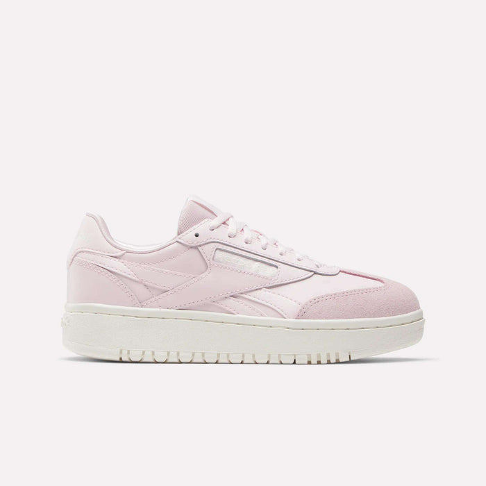 The Campio XT Double Shoes - Big Kids by Reebok are light pink retro low-tops with white laces, subtle branding, and a thick white sole—perfect for girls' collections and shown in profile against a plain white background.