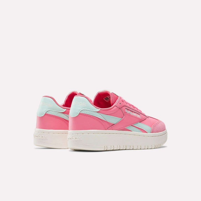 The Reebok Campio XT Double Shoes - Big Kids feature a pink retro design with light blue accents and white soles, shown on a white background—one facing forward, one angled to the side—stylish footwear for everyday wear.