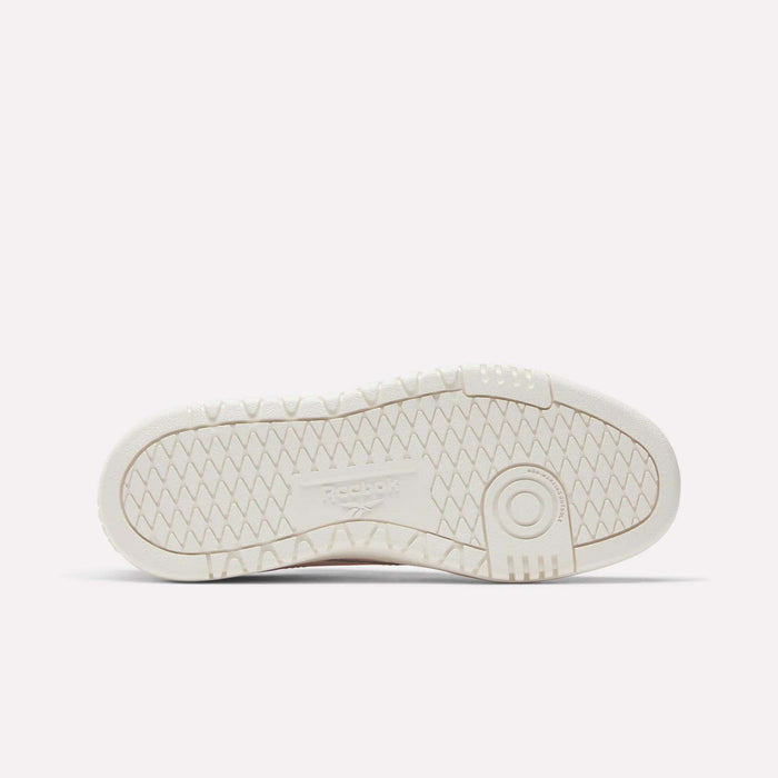 The image shows the sole of Reebok Campio XT Double Shoes - Big Kids in white, featuring a herringbone pattern, circular grip near the ball of the foot, and an embossed Reebok logo at the center—a nod to classic retro sneaker style.