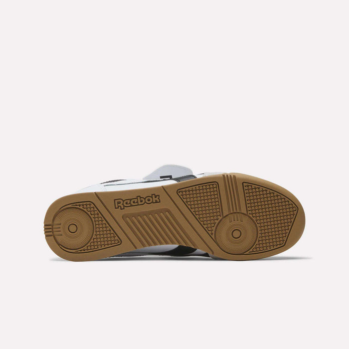 The image displays the sole of the Reebok Campio XT Kilty Shoes, showing a brown rubber outsole with grip-enhancing textures and the Reebok logo, all inspired by tennis style. The shoe is sole-up against a plain white background.