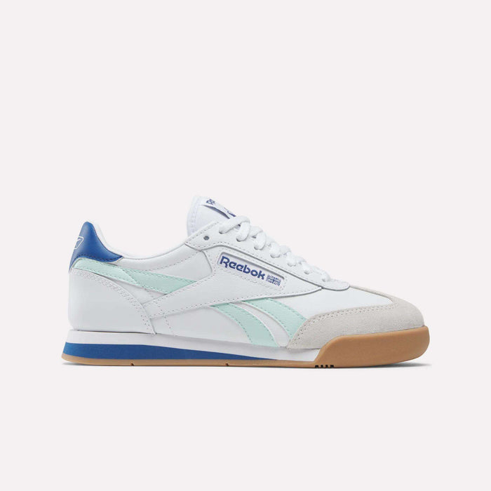 The Reebok Campio XT Shoes for Big Kids feature a white design with light blue and aqua accents, a gum sole, suede toe detail, and blue heel. Shown in side profile on a plain white background—ideal for stylish juniors' soccer shoes.