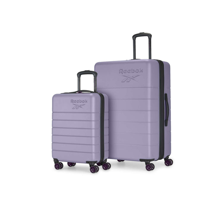 The Reebok Captain 2 Piece Luggage Set features two purple hard-shell suitcases with spinner wheels and extended black handles, shown standing upright on a white background.