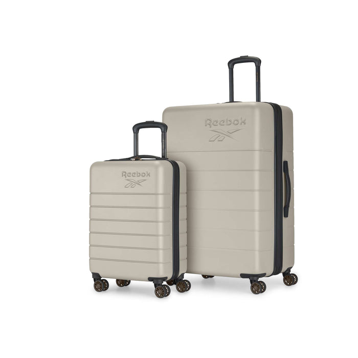Two beige Reebok Captain 2 Piece Luggage Set hard-shell suitcases, one small and one large, each with four spinner wheels, extended black handles, and the Reebok logo on the front, are side by side on a white background.