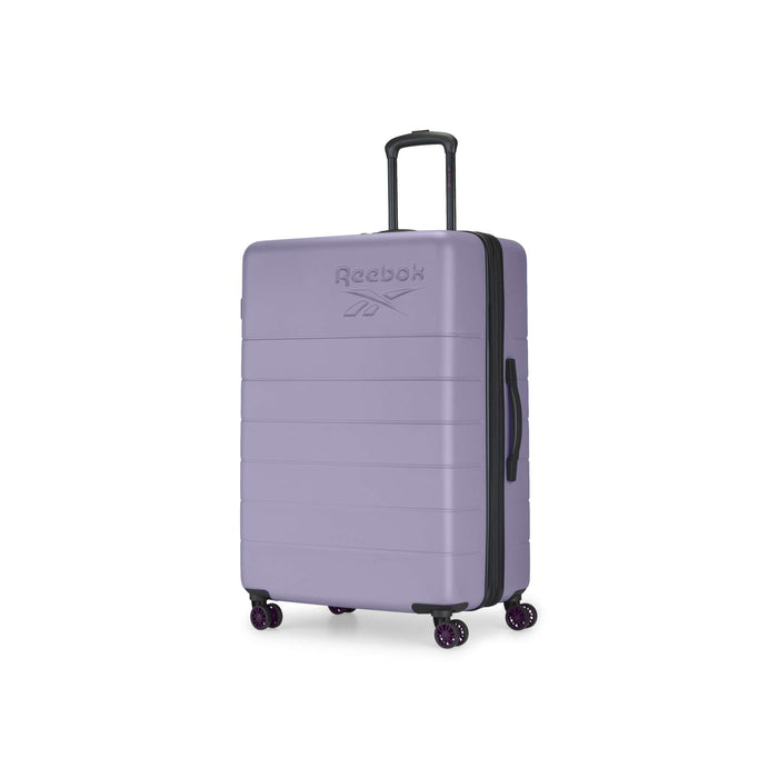 The Reebok Captain 2 Piece Luggage Set features a large, hard-shell lavender suitcase with durable spinner wheels, a black side handle, an extended telescopic handle, and an embossed Reebok logo on the front, shown upright against a white background.