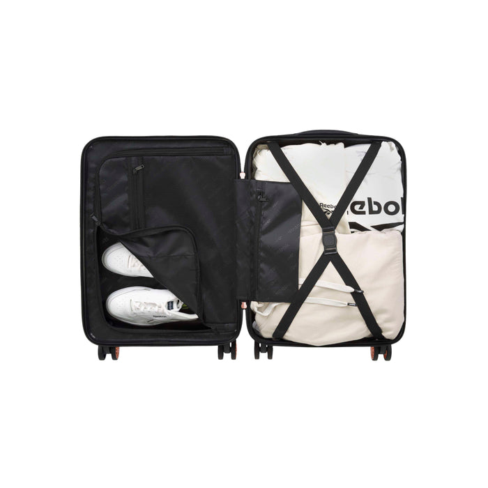 Open black suitcase with two compartments; left side holds a pair of white sneakers in a zippered mesh pocket, right side contains neatly packed clothing secured with crossed straps.