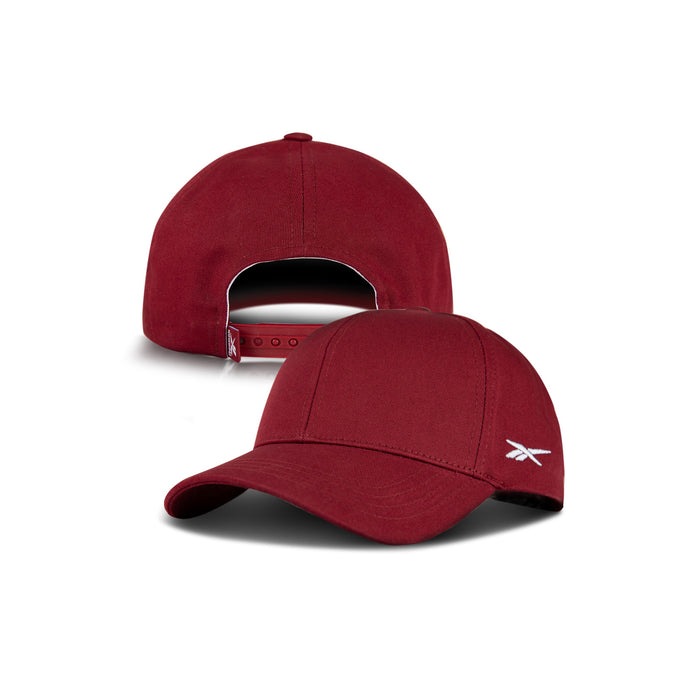 Two maroon Reebok Chroma Cap hats are displayed on a white background: one shows the front with a curved brim and small white logo, while the other reveals its adjustable snapback. Both caps are made of cotton twill.