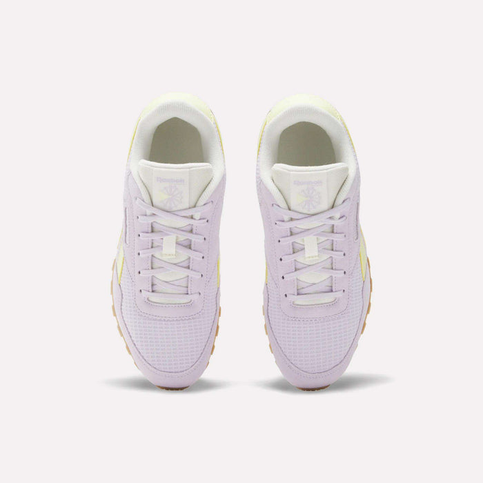 A pair of Reebok Classic AZ Shoes for big kids in pastel purple, shown from above with white laces, white tongues, and gum-colored soles. Heritage running style meets modern comfort on a plain light background.