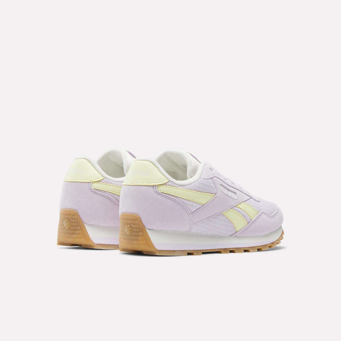 The Reebok Classic AZ Shoes - Big Kids, in pastel purple and yellow with gum soles and foam cushioning, are shown from a rear side angle against a plain white background.