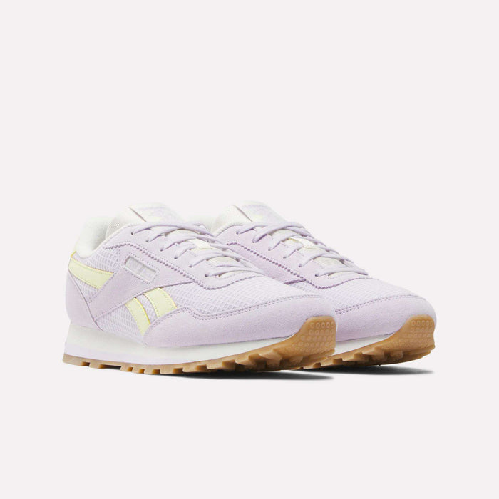 A pair of Reebok Classic AZ Shoes - Big Kids in light purple with yellow side stripes, white midsoles, and brown gum soles, featuring foam cushioning for comfort, displayed on a plain white background.