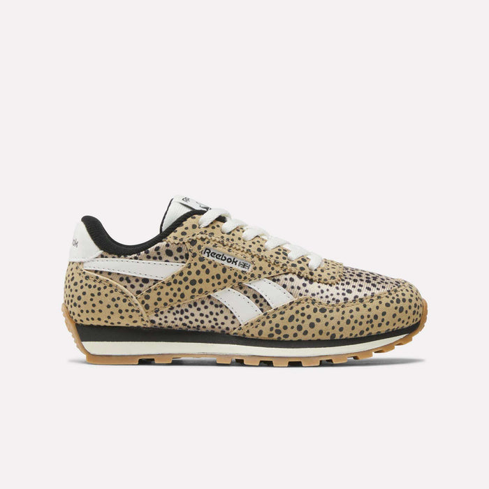 The Reebok Classic AZ Shoes - Little Kids feature a tan upper with black cheetah-like spots, white laces, a white Reebok side logo, and a black and tan sole—ideal for any girls’ shoe collection. Displayed on a plain white background.